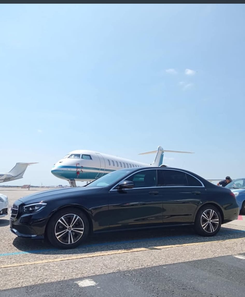 Mercedes Classe E nera di Virtus Autonoleggio accanto a un jet privato